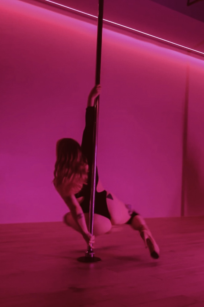 Danse à la barre sous une lumière rose